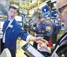  ?? Richard Drew Associated Press ?? INVESTORS are alarmed over the U.S. trade spat with China and a rash of bearish news in the tech sector. Above, New York Stock Exchange traders Monday.