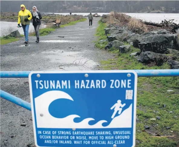  ?? — THE CANADIAN PRESS ?? A couple walk along Whiffin Spit Park on Tuesday following a tsunami warning in Sooke. Tsunami warning sirens went off in Tofino and other coastal communitie­s on B.C.’s West Coast Tuesday morning after a powerful earthquake struck off Alaska.