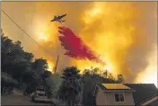  ??  ?? On Aug. 18, an air tanker drops retardant as the LNU Lightning Complex fires tear through the Spanish Flat community in unincorpor­ated Napa County.