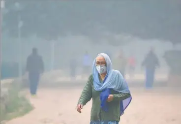  ?? SANCHIT KHANNA/HT PHOTO ?? n An elderly woman wears a mask while taking a walk in Deer Park, New Delhi, on Monday.