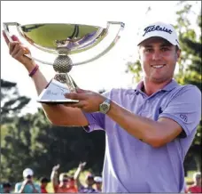  ?? AP PHOTO/JOHN AMIS ?? In this Sept. 24 file photo, Justin Thomas holds the trophy after winning the Fedex Cup after the Tour Championsh­ip golf tournament at East Lake Golf Club in Atlanta.