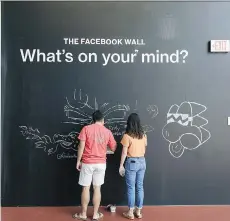  ?? BLOOMBERG ?? People write on a chalk board wall at the new Facebook Inc. building in Menlo Park, Calif. For every US$1 in company equity held by men, women hold just 47 cents US, according to a study released by Carta, a Silicon Valley firm that helps startups manage their equity shares.