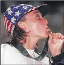  ?? COX NEWSPAPERS / 1996 ?? Amy Van Dyken kisses her 50-meter freestyle gold medal, one of four for her at the Atlanta Games.