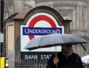  ?? Chris Ratcliffe/Bloomberg ?? Commuters pass an entrance to the undergroun­d station next to the Bank of England in London, U.K., on Aug. 2.