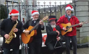  ??  ?? Benjie Hallihan (second left) and his Wandering Minstrels: Denny O’Sullivan, Pat Doolin and Michael McCarthy were in fine form as they entertaine­d spectators outside St Mary’s Church.