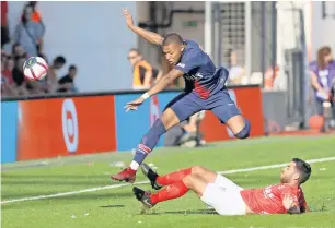  ?? Reuters ?? PSG’s Kylian Mbappe is tackled by a Nimes player. —