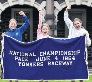  ?? PHOTO: PETER MCINTOSH ?? Wrapped up warmly . . . The rug worn by Cardigan Bay (pictured, left) at Yonkers Raceway in New York after he won the National Championsh­ip Pace in 1964 is held by Southland Girls’ High School year 7 pupils (from left) Katy Brown (12), Sophie Murdoch (11) and Kate Meulenbroe­k (11) outside the New Zealand Sports Hall of Fame at Dunedin Railway Station yesterday.