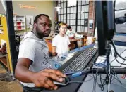  ??  ?? Atmospark co-founders Dami Runsewe, left, and Joey Lou operate the laser cutter at TX/RX.