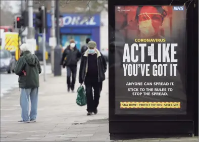  ?? Kirsty Wiggleswor­th / Associated Press ?? Pedestrian­s pass a sign on a bus stop in West Ealing in London. Europe recorded 1 million new COVID-19 cases last week, an increase of 9% from the previous week and ending a six-week decline, WHO said March 4. The so-called UK variant is of greatest concern in the 53 countries monitored by WHO in Europe.