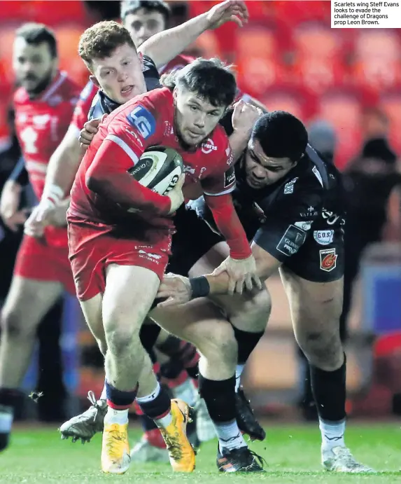  ??  ?? Scarlets wing Steff Evans looks to evade the challenge of Dragons prop Leon Brown.