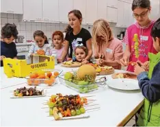  ?? Foto: Annemarie Rencken ?? Die Kinder bereiten gemeinsam Obstspieße bei der integrativ­en Woche des Pfarrzen trums Friedberg zu.