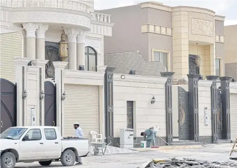  ?? AFP ?? Foreign labourers work on the constructi­on of new houses in Riyadh.