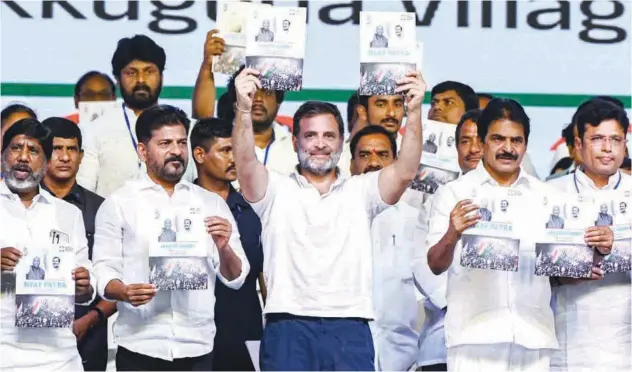  ?? Agence France-presse ?? Rahul Gandhi holds the party manifesto during an election campaign meeting on the outskirts of Hyderabad on Saturday.