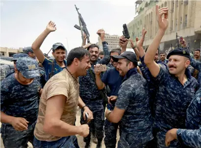  ?? Reuters ?? Iraqi federal policemen celebrate in the Old City of Mosul on Saturday. —