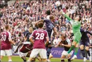  ?? Kirsty Wiggleswor­th / Associated Press ?? West Ham’s goalkeeper Lukasz Fabianski, in green, makes a save against Manchester City on Sunday.