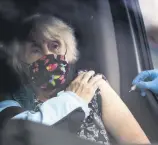  ??  ?? A woman receives a flu vaccine in her car at a drive-thru flu clinic in Little France, Edinburgh.