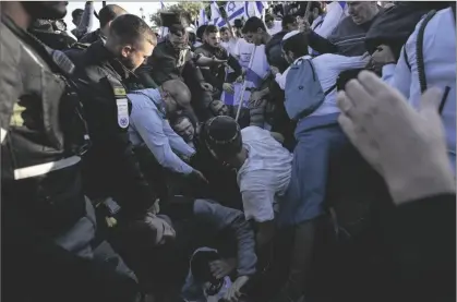  ?? AP PHOTO/ARIEL SCHALIT ?? Israeli police officer block right wing activists from marching towards the Old City in Jerusalem, on Wednesday.