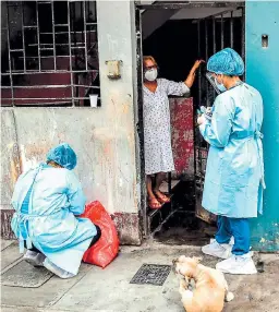  ??  ?? BRIGADA. Un trabajador de salud peruano se prepara para realizar una prueba de covid-19 a una mujer en su casa.