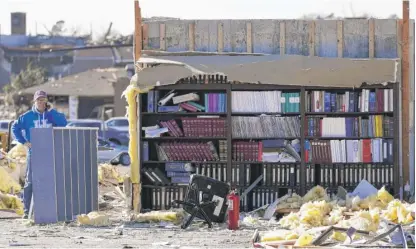  ?? MARK HUMPHREY/AP ?? Attorney Chuck Foster talks on the phone Sunday in what was his law office before it was destroyed in Friday’s storm in Mayfield, Ky.