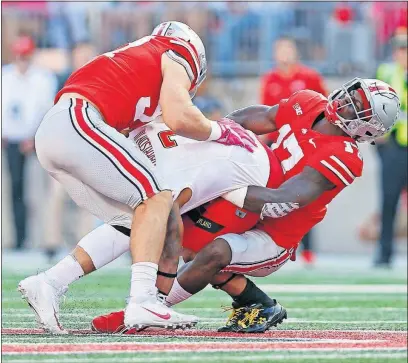  ?? ROBERTSON/DISPATCH] [KYLE ?? Ohio State defensive lineman Nick Bosa, left, and linebacker Jerome Baker corral Maryland running back Lorenzo Harrison III during the second quarter. Earlier, Baker had returned a fumble 20 yards for a touchdown.