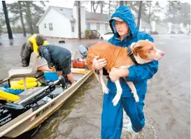  ??  ?? Voluntario­s ayudan a rescatar a residentes y a sus mascotas.