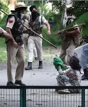  ?? PHOTOS AFP ?? Une adepte du gourou indien arrêté hier implore les forces de l’ordre de l’épargner alors que des heurts font rage.