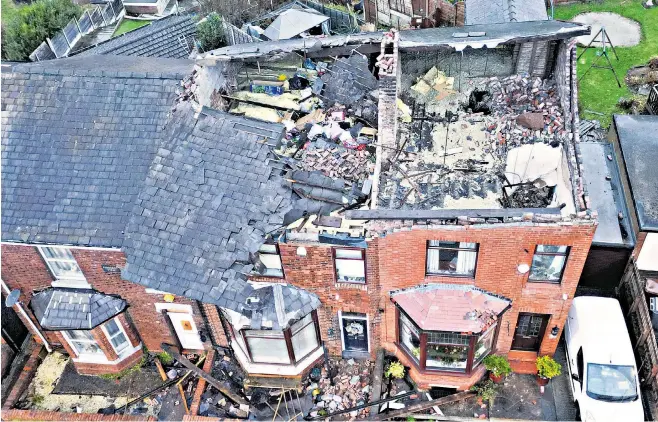  ?? ?? Stalybridg­e aftermath... from top left: car crushed by falling tree; removing another uprooted tree; police officer inspects the damage; main: these properties lost their roof in the storm. Below left: in Cupar, Fife, Carol Watters amid the damage to her home; council vehicle tries to clear flooding as a police car struggles through the water in Dumbarton