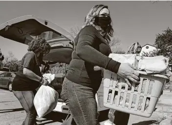  ?? Ronald Cortes / Contributo­r ?? Nina Gribben helps unload donations Tuesday. People dropped off items for the homeless during a drive-by event at the San Fernando Homeless Resource Hub, run by the city’s Department of Human Services.