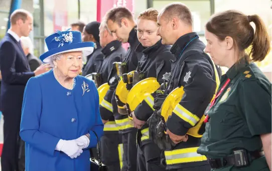  ??  ?? Britain’s Queen Elizabeth meets firefighte­rs and paramedics during a visit to the Westway Sports Center, which is providing temporary shelter for those who have been made homeless by the fire at Grenfell Tower in London. (AP)
