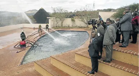  ?? Picture: ROGAN WARD ?? DIRTY POOL: Firefighte­rs attempt to show that the swimming pool at President Jacob Zuma’s Nkandla homestead is really a security feature