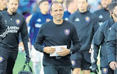  ?? JOE BURBANK/ORLANDO SENTINEL ?? Orlando City coach Oscar Pareja, center, said he hopes Major League Soccer brings all teams to Orlando and resumes play.