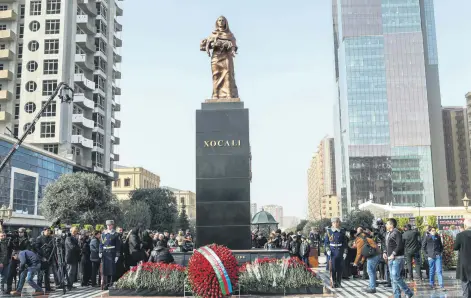  ??  ?? Azerbaijan­i citizens commemorat­e the anniversar­y of the Khojaly Massacre, laying flowers by the Cry of the Mother Monument erected in honor of the massacre victims in the capital Baku, Azerbaijan, Feb. 26, 2017.