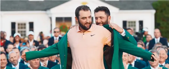  ?? Photo: AP ?? Jon Rahm, of Spain, puts the green jacket on Scottie Scheffler after he won the Masters at Augusta National Golf Club. Scheffler, who is 27, is the fourth-youngest multiple Masters winner.