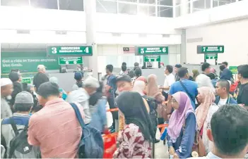  ??  ?? Part of the crowd kept waiting for immigratio­n clearance as only two counters were manned at the Tawau Airport Arrival Hall in the evening of December 28, 2018.