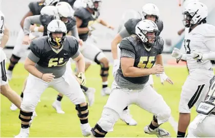  ?? STEPHEN M. DOWELL/ORLANDO SENTINEL ?? UCF center Matt Lee (55) works through drills with the offensive linemen during a recent spring practice. The Knights return a wealth of experience and depth up front, which is good news for new offensive line coach Herb Hand.