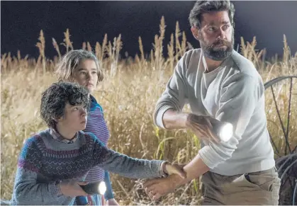  ?? Photos / Paramount Pictures via AP ?? Noah Jupe, Millicent Simmonds and John Krasinski — and Emily Blunt, and John Krasinski (left) — in scenes from AQuietPlac­e.