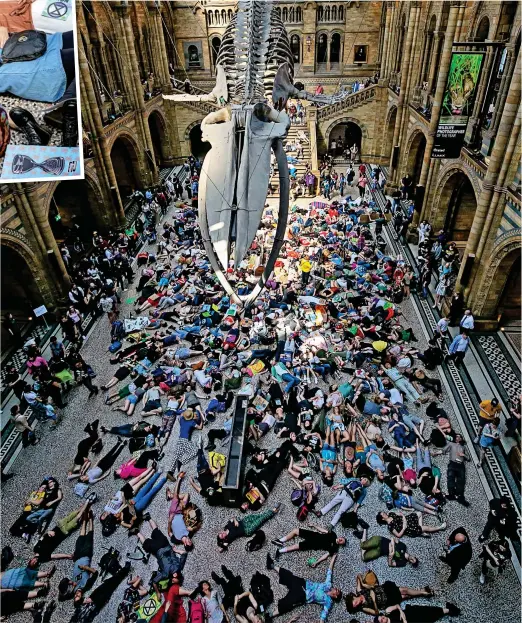  ??  ?? You’re in the way! Tourists squeeze around the edge of London’s Natural History Museum to avoid protesters yesterday