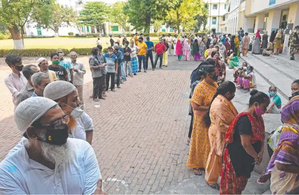  ??  ?? Voters queue up to cast their ballot in West Bengal's state legislativ­e assembly elections. Picture: AFP