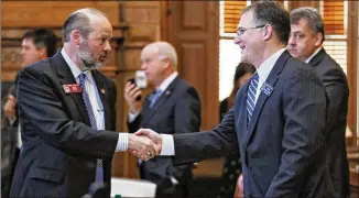  ?? BOB ANDRES PHOTOS / BANDRES@AJC.COM ?? Sen. William Ligon (right), R-Brunswick, is congratula­ted by Rep. Barry Fleming, R-Harlem, after the bill passes. Flemming sponsored the bill in the House and Ligon carried it in the Senate.