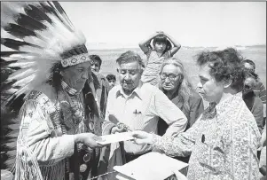  ?? The Associated Press ?? 1973: In this May 5, 1973, file photo, Hank Adams, right, permanent representa­tive of the Indians Trial of Broken Treaties presents letter from the White House to traditiona­l Sioux Chief Frank Fools Crow, left, at border of Pine Ridge Reservatio­n in Scenic, S.D. Adams, Assiniboin­e-Sioux, died Dec.
21 at St. Peter’s Hospital in Olympia, Wash., according to the Northwest Indian Fisheries Commission. Influentia­l Native American rights advocate and author Vine Deloria Jr. called Adams the “most important Indian” because he was involved with nearly every major event in American Indian history from the 1960s forward.