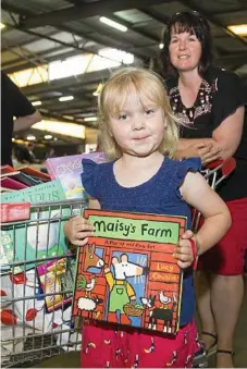 ??  ?? Kylie Berlin and daughter Mia, 5, travelled from Dalby to fill up a trolley-load of books to keep them reading over the next year.