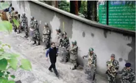  ??  ?? DARJEELING, India: Indian army personnel stand guard along a street during an indefinite strike called by the Gorkha Janmukti Morcha (GJM) yesterday. — AFP