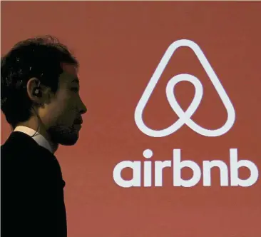  ??  ?? In the spotlight: A man walks past a logo of Airbnb in Tokyo, Japan. It’s too early to say what impact the new rules would have on Uber and Airbnb, but they highlight increasing scrutiny by regulators globally and growth challenges facing these new...