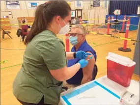  ?? Brian Gioiele / Hearst Connecticu­t Media ?? Caitlin Kelley, LPN, administer­s a COVID-19 vaccine to Christophe­r Nicholas Coideo of Seymour April 9 at the Naugatuck Valley Health District vaccine clinic at the Seymour Community Center.