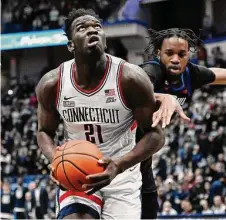  ?? Jessica Hill/Associated Press ?? UConn’s Adama Sanogo (21) looks to shoot as DePaul’s Nick Ongenda defends in the first half on Wednesday.