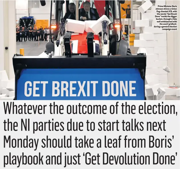  ??  ?? Prime Minister Boris Johnson drives a Union flag-themed JCB, with the words “Get Brexit Done” inside the digger bucket, through a fake wall emblazoned with
the word ‘gridlock’, during a general election
campaign event