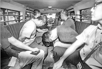  ?? — Reuters photo ?? Suspects, part of a group of 17 detained over their part in an alleged oil theft at Shell’s Pulau Bukom refinery, arrive in a van at the State Courts, Singapore.