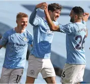  ?? — AP ?? Manchester City’s John Stones (second left) celebrates with teammates after scoring against West Ham in their English Premier League match at the Etihad stadium in Manchester on Saturday. The hosts won 2-1.