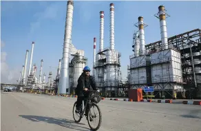  ?? VAHID SALEMI / THE ASSOCIATED PRESS FILES ?? An oil refinery south of Iran’s capital, Tehran. The global oil market is looking for signs that Washington may extend sanctions waivers for Iran’s key customers in early May.