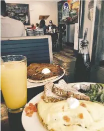  ?? PHOTO BY SUSAN PIERCE ?? One blueberry pancake is the size of a dinner plate, easily enough for two. The Works omelet comes with a slice of whole-grain toast and a serving of greens, in this case spinach dressed with a lemon vinaigrett­e.